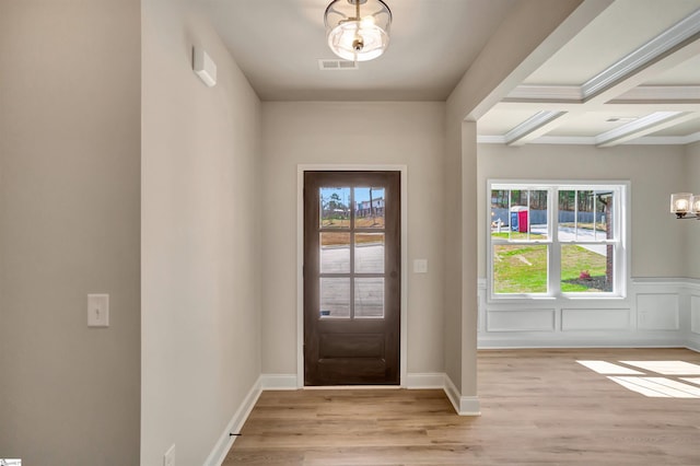 doorway to outside featuring light hardwood / wood-style floors, coffered ceiling, beamed ceiling, and an inviting chandelier