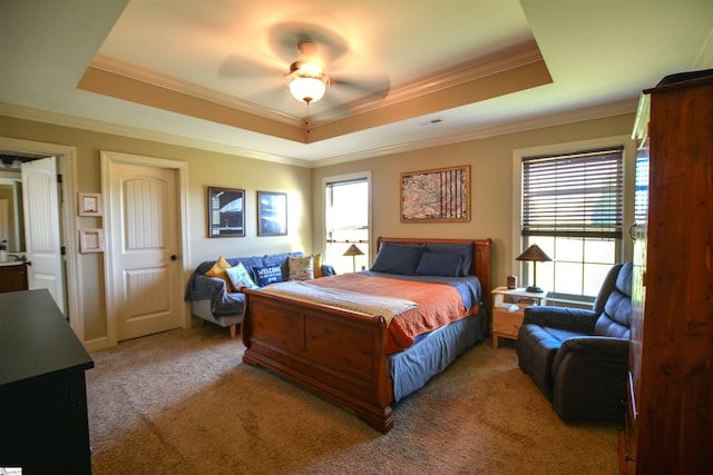 bedroom with ceiling fan, a raised ceiling, crown molding, and carpet