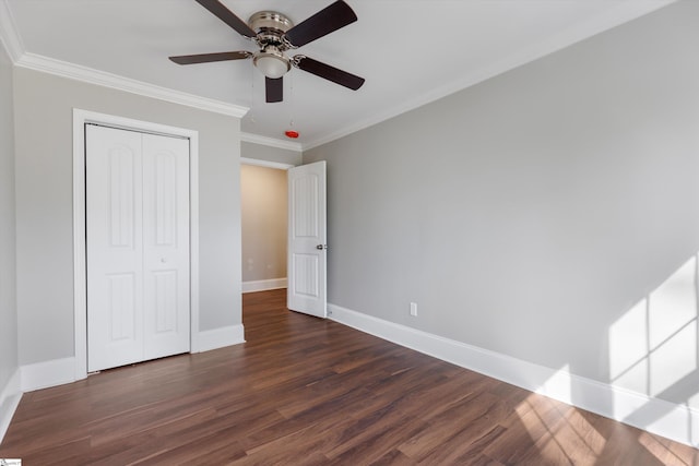 unfurnished bedroom with crown molding, dark hardwood / wood-style floors, a closet, and ceiling fan