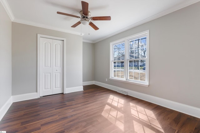 unfurnished bedroom featuring ornamental molding, a closet, ceiling fan, and dark hardwood / wood-style floors