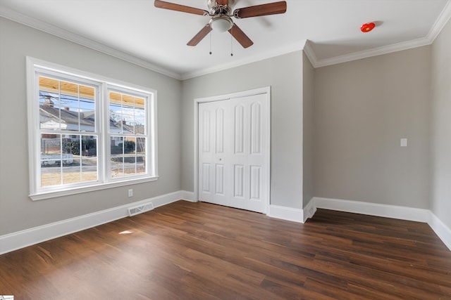 unfurnished bedroom featuring ornamental molding, a closet, ceiling fan, and dark hardwood / wood-style flooring