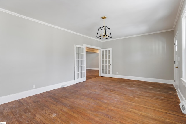 empty room with french doors, crown molding, and dark wood-type flooring