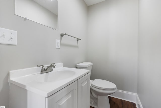 bathroom featuring vanity, toilet, and hardwood / wood-style floors