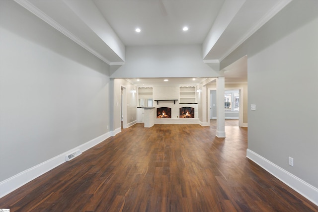 unfurnished living room featuring dark hardwood / wood-style floors and ornate columns