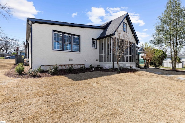 view of front of house featuring a sunroom and a front yard