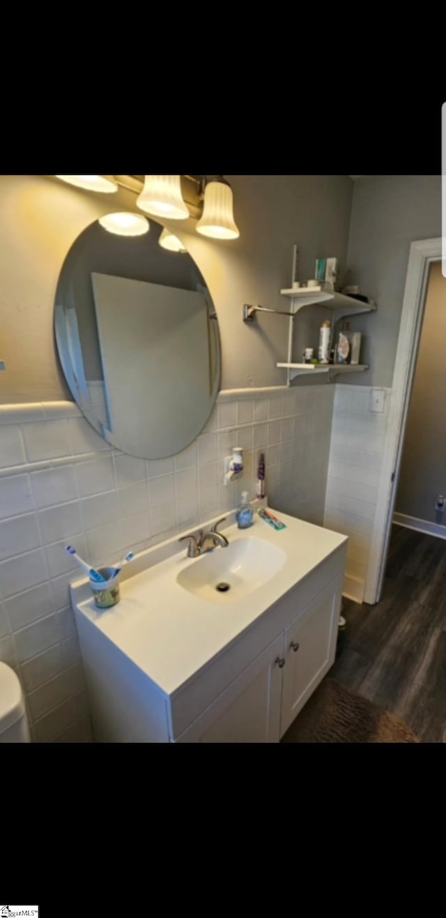 bathroom with tile walls, hardwood / wood-style floors, large vanity, backsplash, and toilet