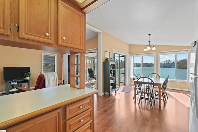 interior space featuring light wood-type flooring, vaulted ceiling, a chandelier, and a wealth of natural light