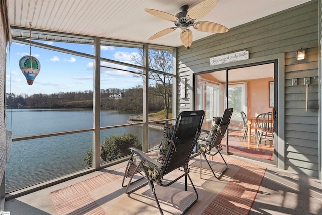 sunroom / solarium featuring a water view and ceiling fan