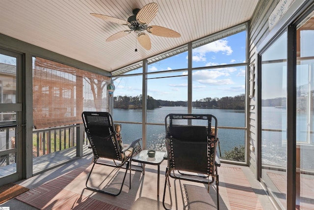 sunroom featuring ceiling fan, a water view, and a wealth of natural light