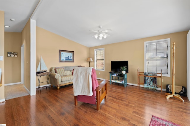 living room with dark hardwood / wood-style flooring, ceiling fan, and lofted ceiling