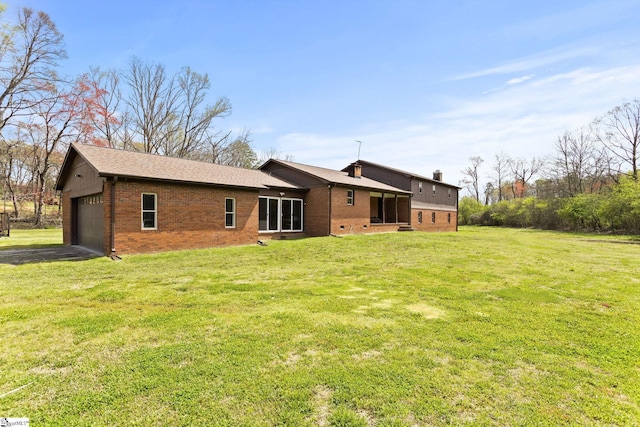 rear view of property with a yard and a garage