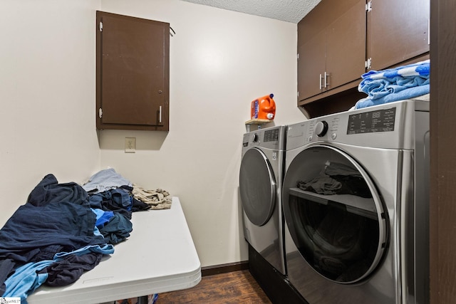 laundry area featuring dark wood-type flooring, cabinets, and washer and clothes dryer