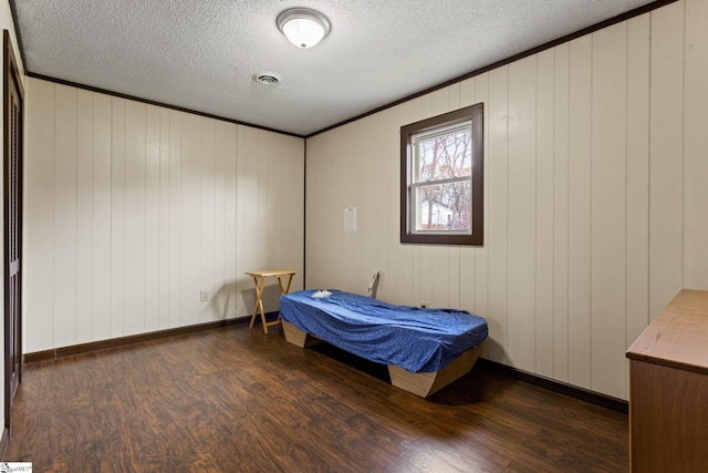 bedroom with ornamental molding, dark hardwood / wood-style floors, and a textured ceiling