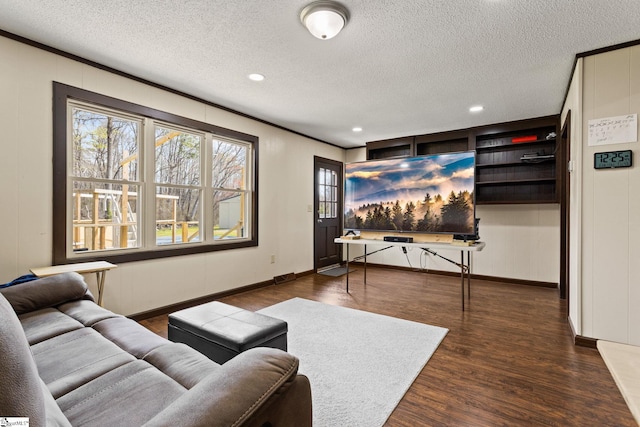 living room with a textured ceiling, dark hardwood / wood-style floors, and built in shelves