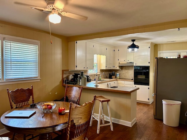 kitchen featuring black appliances, white cabinets, sink, dark hardwood / wood-style flooring, and kitchen peninsula