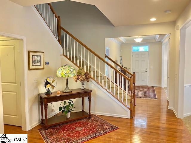 foyer with ornamental molding and light hardwood / wood-style flooring