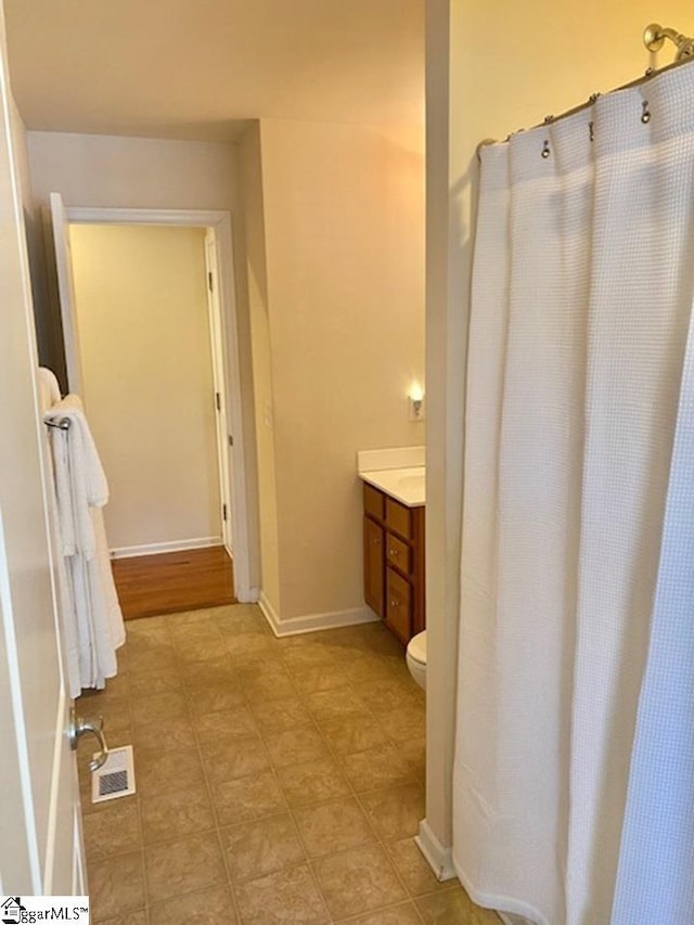 bathroom with toilet, hardwood / wood-style floors, and vanity