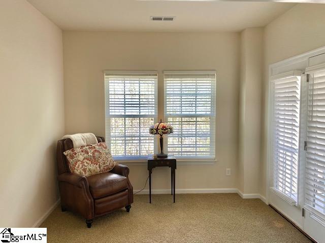 living area featuring light carpet and a healthy amount of sunlight