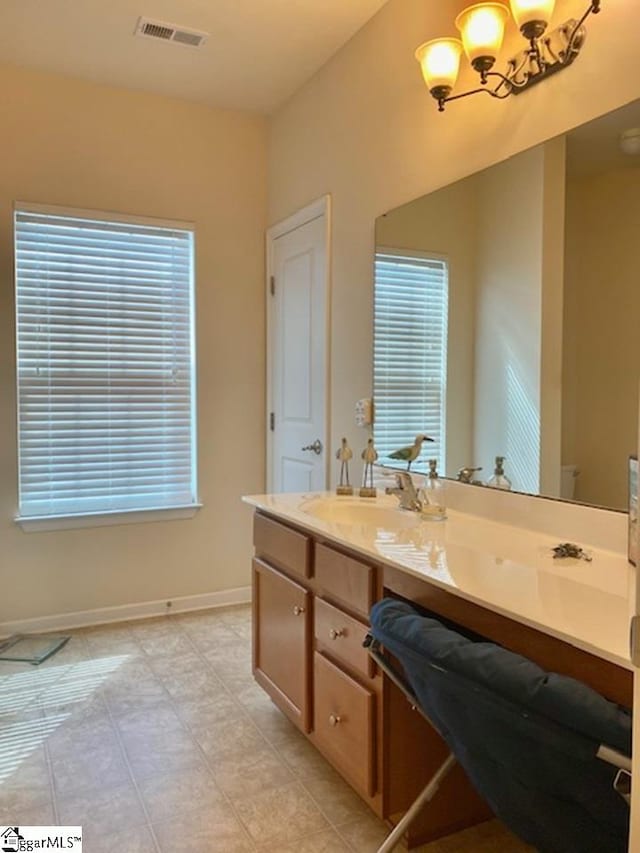 bathroom featuring tile floors, dual vanity, and a chandelier