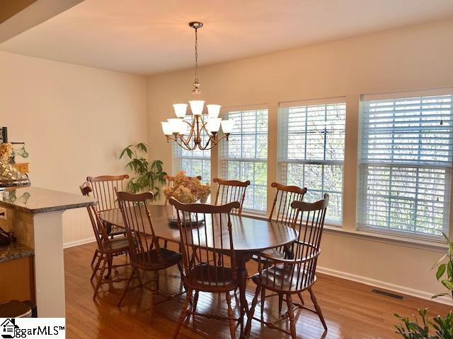 dining space featuring dark hardwood / wood-style floors and a chandelier