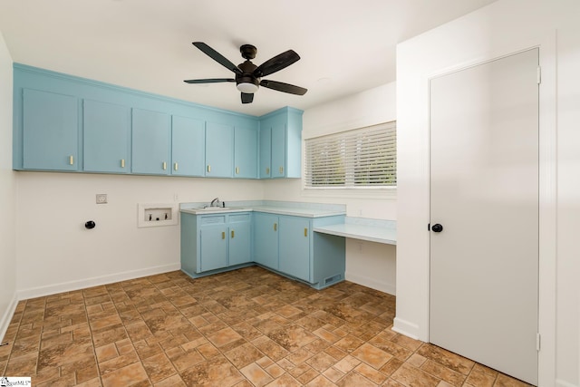 kitchen featuring tile floors, ceiling fan, built in desk, sink, and blue cabinets