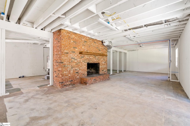 basement with brick wall and a brick fireplace