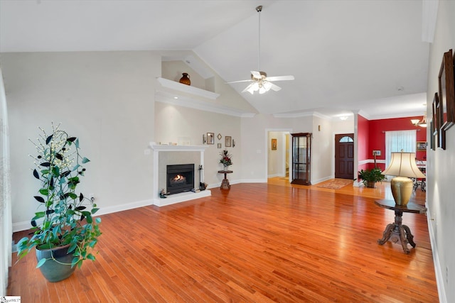 living room with ornamental molding, high vaulted ceiling, ceiling fan, and light wood-type flooring