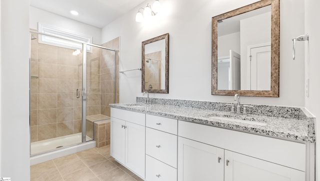 bathroom featuring tile patterned flooring, vanity, and a shower with door