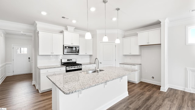 kitchen featuring appliances with stainless steel finishes, sink, white cabinets, and decorative light fixtures