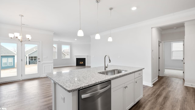 kitchen featuring white cabinetry, sink, decorative light fixtures, and stainless steel dishwasher