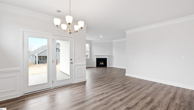 unfurnished living room featuring ornamental molding, a notable chandelier, and dark hardwood / wood-style flooring