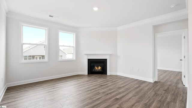 unfurnished living room featuring hardwood / wood-style floors and crown molding