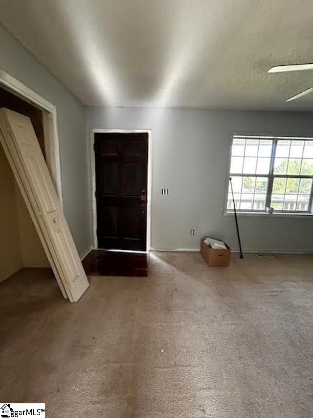 foyer entrance featuring ceiling fan and light colored carpet