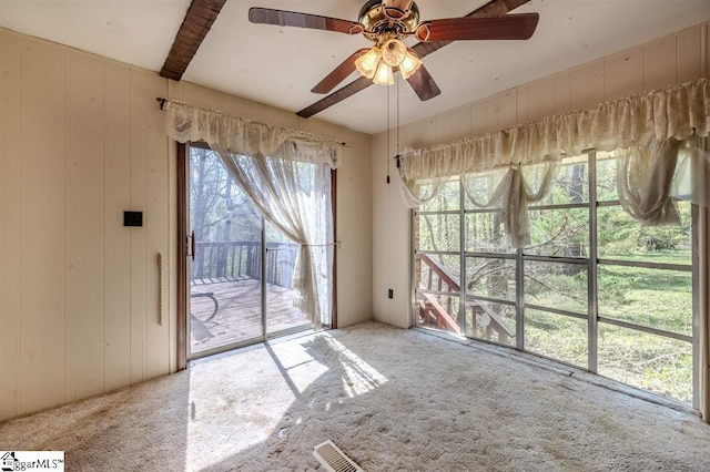 spare room with a wealth of natural light, ceiling fan, and light carpet