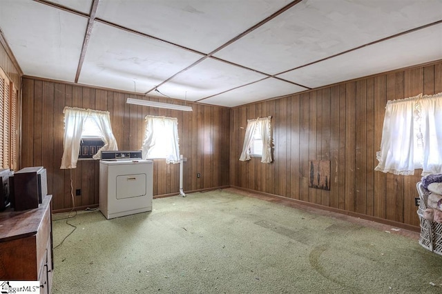 unfurnished office featuring wooden walls, a wealth of natural light, and washer / dryer