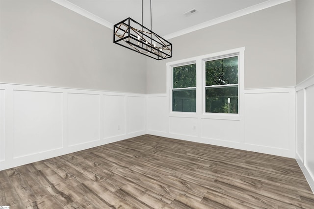 spare room with dark hardwood / wood-style flooring, a chandelier, and ornamental molding