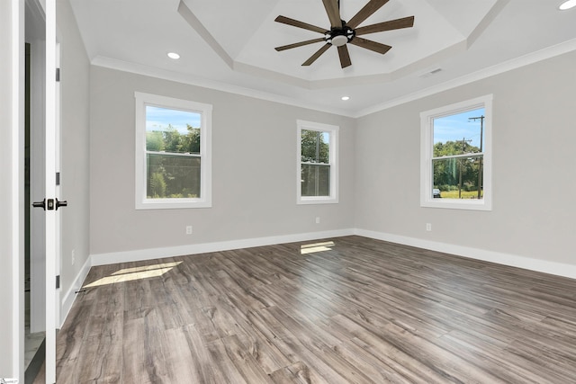 spare room featuring crown molding, wood-type flooring, ceiling fan, and a tray ceiling