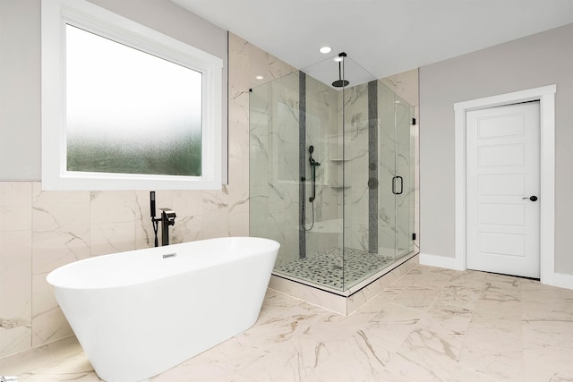 bathroom featuring tile walls, shower with separate bathtub, and tile flooring