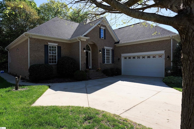 traditional-style home featuring concrete driveway, brick siding, an attached garage, and roof with shingles