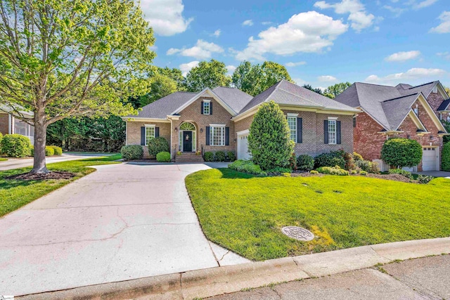 view of front of home with driveway, a front lawn, and brick siding