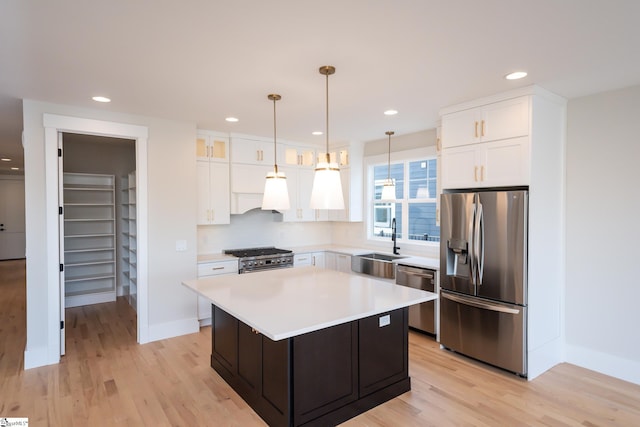 kitchen featuring a kitchen island, light wood-type flooring, stainless steel appliances, and white cabinetry