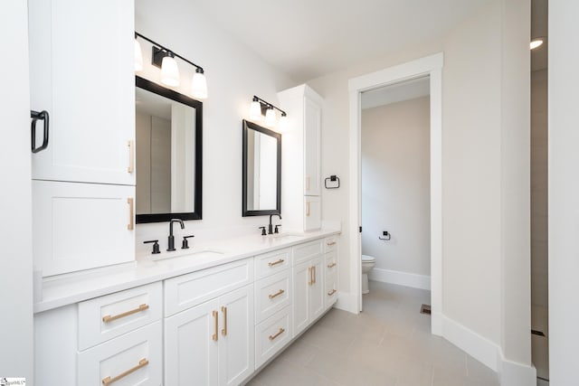 bathroom featuring double sink, toilet, tile flooring, and large vanity