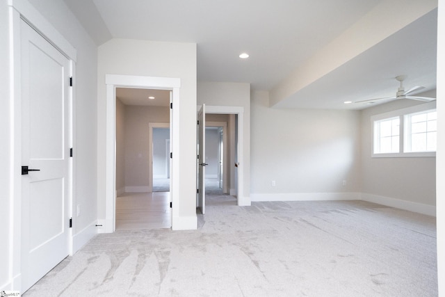 empty room with ceiling fan and light carpet