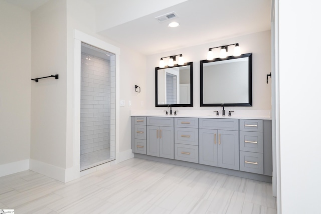 bathroom featuring dual bowl vanity, tiled shower, and tile flooring