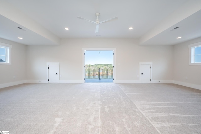 carpeted empty room featuring plenty of natural light and ceiling fan