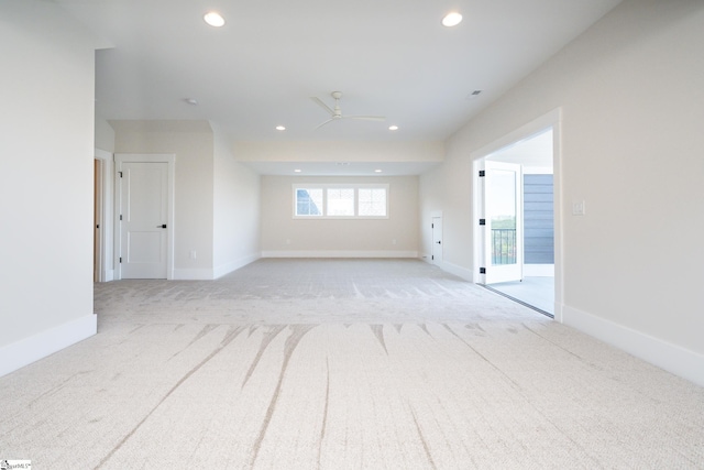 unfurnished room with light colored carpet and ceiling fan