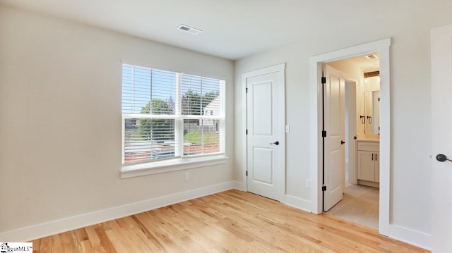 unfurnished bedroom featuring light hardwood / wood-style flooring and ensuite bathroom