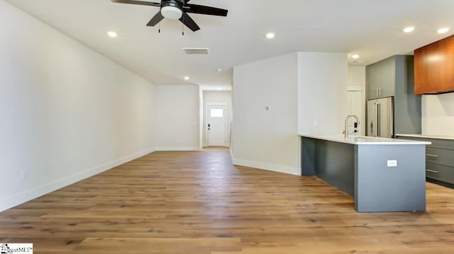 interior space with sink, light hardwood / wood-style floors, and ceiling fan