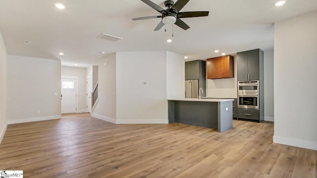 kitchen with sink, light hardwood / wood-style flooring, ceiling fan, and stainless steel appliances