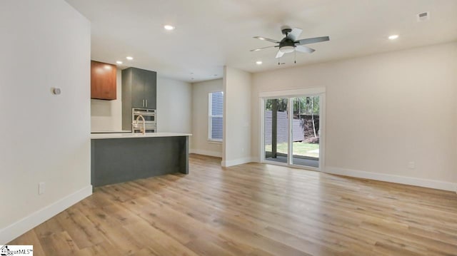 interior space with light hardwood / wood-style floors, ceiling fan, and sink